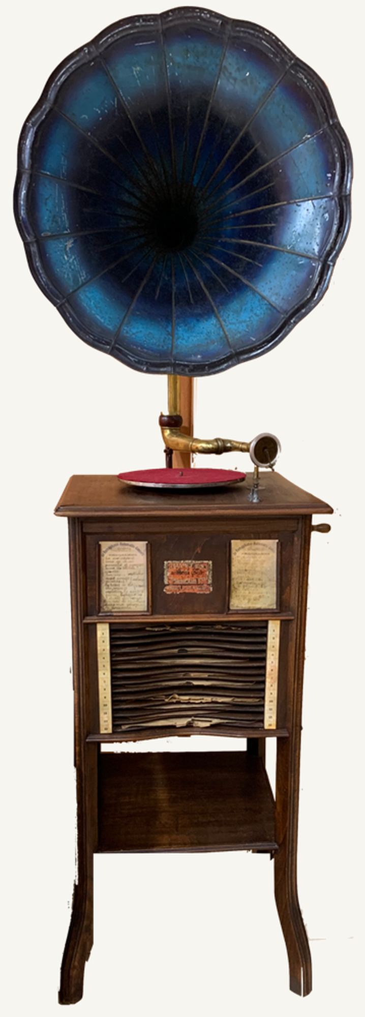 Gramófono de monedas Ramophone: mueble de madera con bocina azul de gajos, plato con disco rojo y estantería con discos bajo el tablero