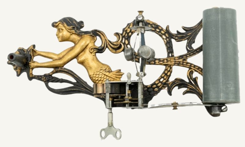 Mecanismo del fonógrafo Puck Sirene sobre una base de hierro fundido dorado con una sirena tendida entre olas