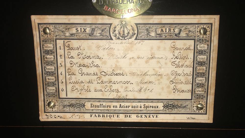 Tarjeta de melodías manuscrita de una caja de música de seis aires, con placa del comercio D. Fradera y Cía. de Barcelona